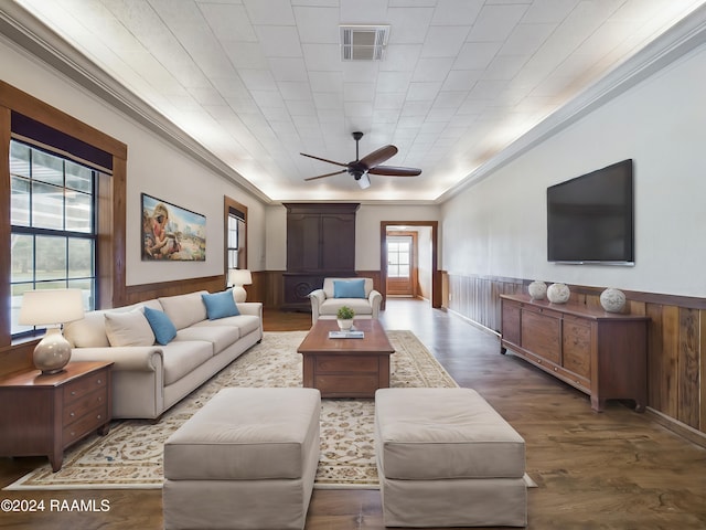 living room featuring a wainscoted wall, crown molding, visible vents, wood walls, and wood finished floors