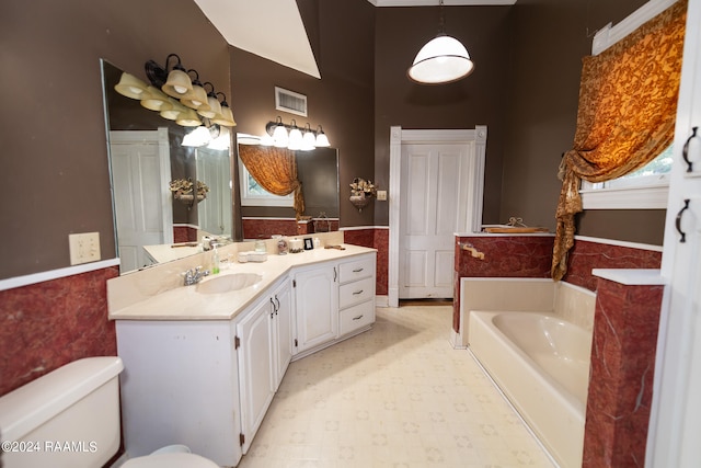 bathroom featuring vanity, toilet, a wealth of natural light, and a bathing tub