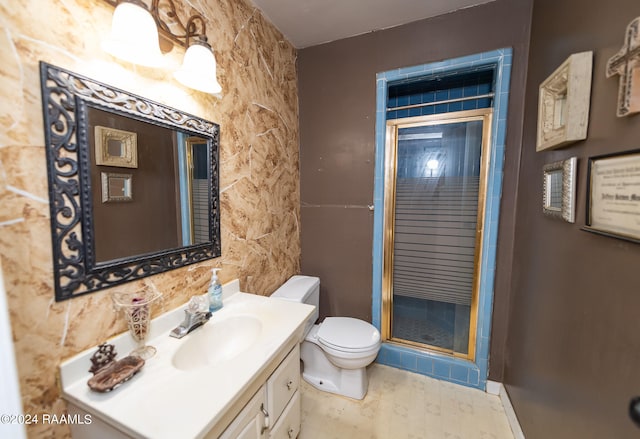 bathroom with toilet, a shower with door, and vanity