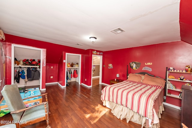 bedroom with dark wood-type flooring, a walk in closet, and a closet