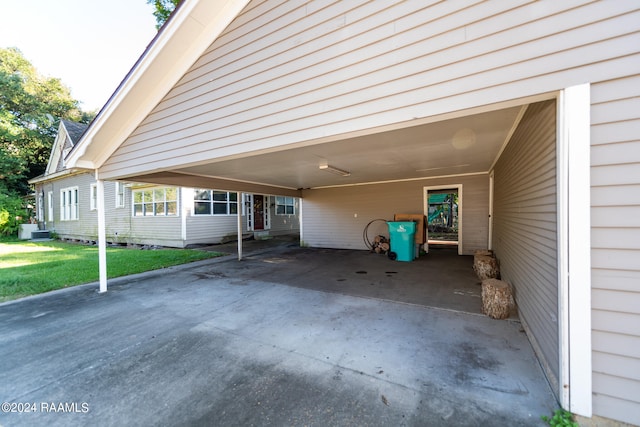 view of parking / parking lot with a lawn and a carport