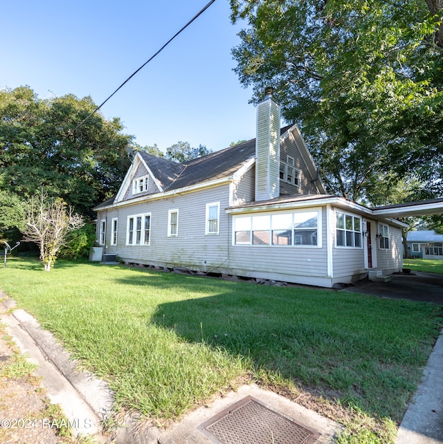 view of side of home with a lawn