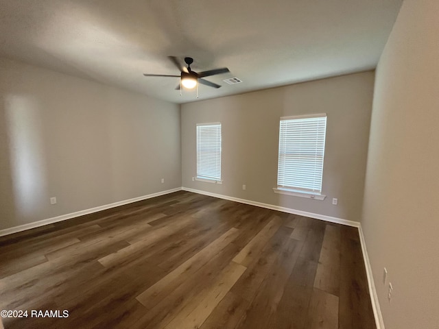 spare room featuring ceiling fan and dark wood-type flooring