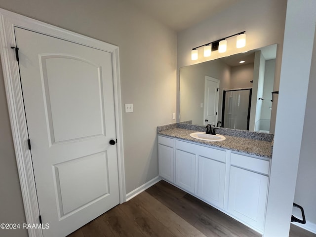 bathroom featuring vanity, wood-type flooring, and a shower with door