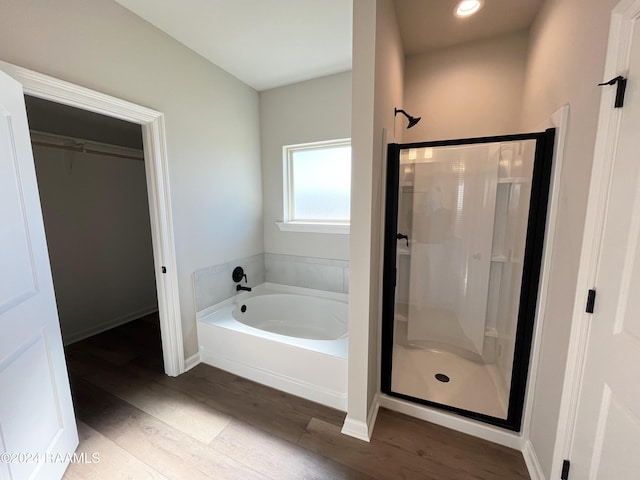 bathroom featuring independent shower and bath and hardwood / wood-style flooring