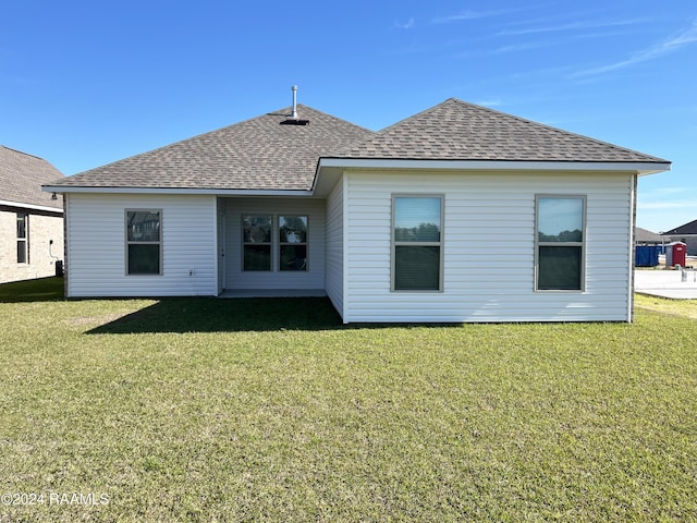 rear view of house featuring a lawn