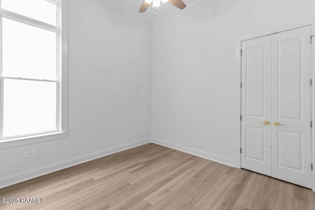unfurnished room featuring light wood-style flooring, a ceiling fan, and baseboards