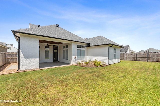 rear view of property featuring a patio area, a yard, and ceiling fan