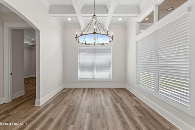 unfurnished dining area with a notable chandelier, hardwood / wood-style floors, and coffered ceiling