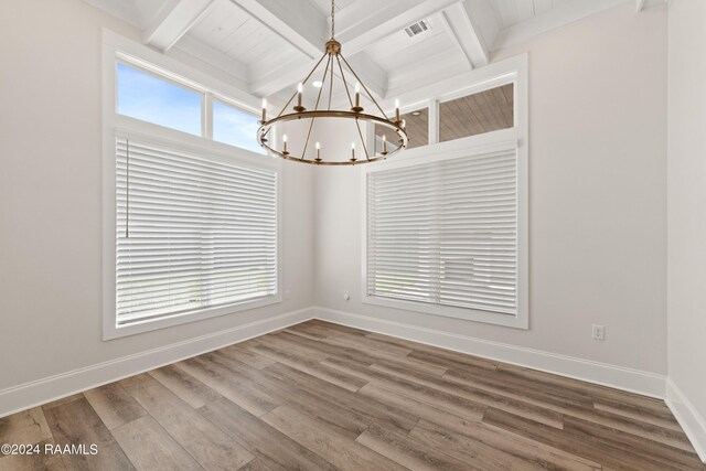 unfurnished dining area with a chandelier, beamed ceiling, and wood-type flooring