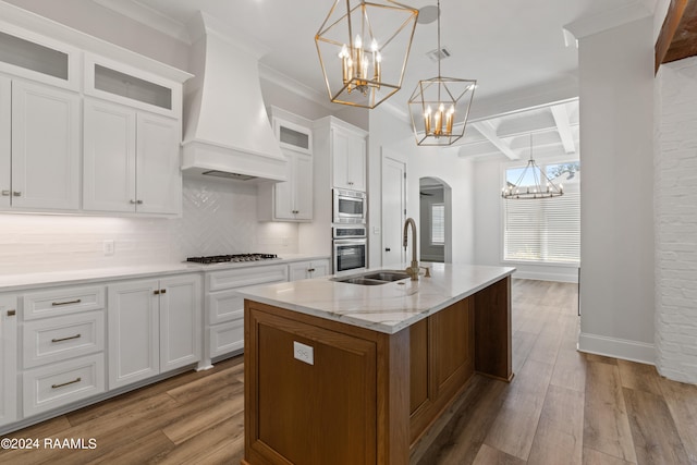 kitchen featuring premium range hood, hardwood / wood-style floors, decorative backsplash, white cabinetry, and coffered ceiling