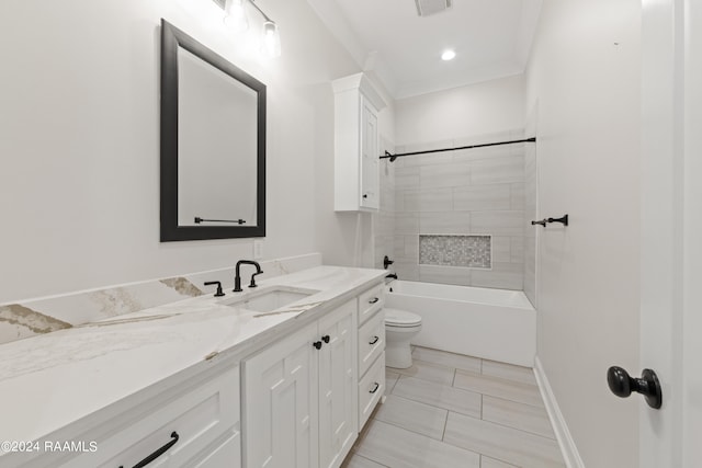 full bathroom featuring tiled shower / bath, ornamental molding, tile patterned flooring, vanity, and toilet