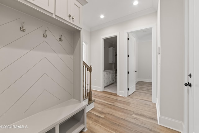 mudroom with light wood-type flooring and crown molding