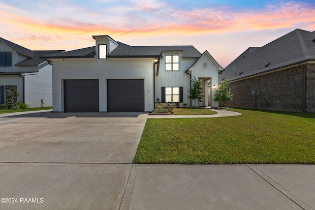 view of front of house featuring a garage and a yard