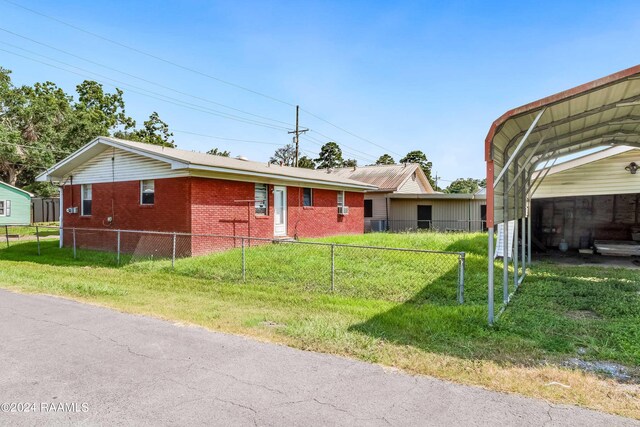 ranch-style home with a front yard and a carport