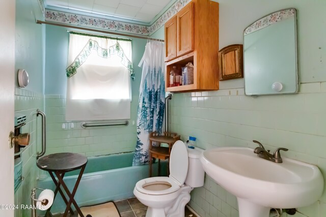 full bathroom featuring shower / tub combo with curtain, tile patterned flooring, tile walls, toilet, and sink