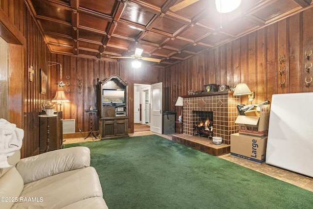 carpeted living room featuring a tile fireplace, wood walls, beamed ceiling, coffered ceiling, and wooden ceiling