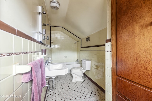 bathroom with tile walls, sink, tile patterned floors, and lofted ceiling