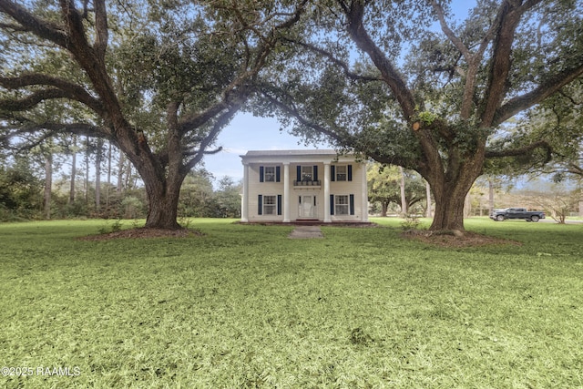 greek revival house featuring a front yard