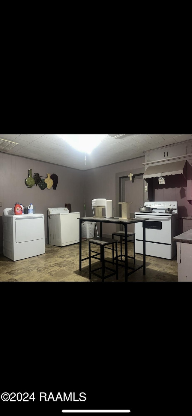 interior space with separate washer and dryer, white electric stove, and wood-type flooring