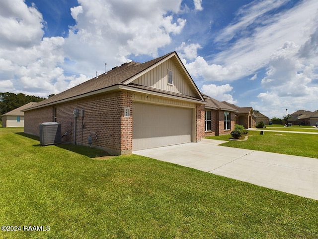 view of front of house with central AC, a garage, and a front lawn