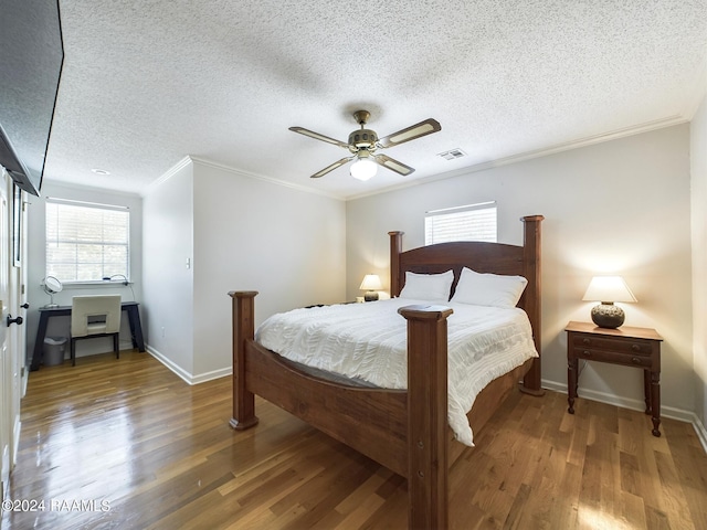 bedroom with ceiling fan, ornamental molding, dark hardwood / wood-style flooring, and a textured ceiling