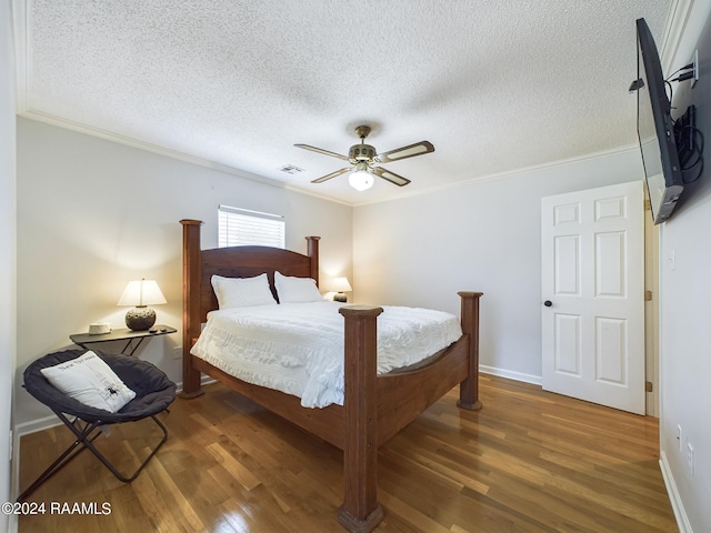 bedroom with ceiling fan, ornamental molding, dark hardwood / wood-style flooring, and a textured ceiling