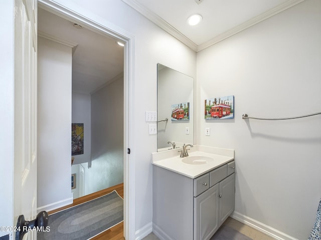 bathroom with hardwood / wood-style flooring, ornamental molding, and vanity