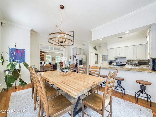 dining space featuring ceiling fan with notable chandelier, crown molding, and light hardwood / wood-style flooring