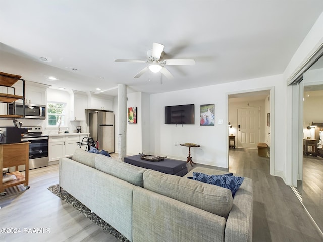 living room with ceiling fan and light hardwood / wood-style floors