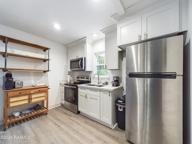 kitchen featuring light wood-type flooring, sink, appliances with stainless steel finishes, and white cabinets