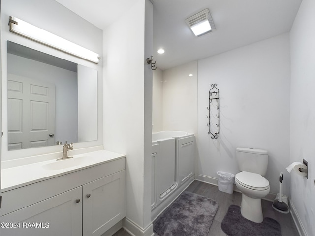 bathroom with wood-type flooring, toilet, and vanity