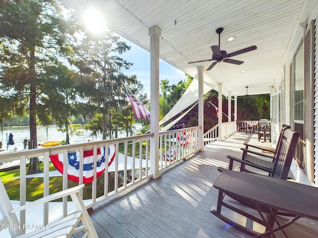 deck with ceiling fan and a water view