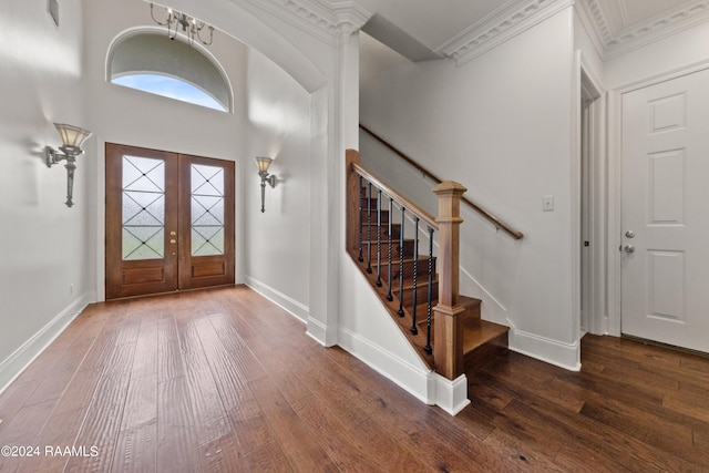 entrance foyer featuring stairs, crown molding, baseboards, and wood-type flooring