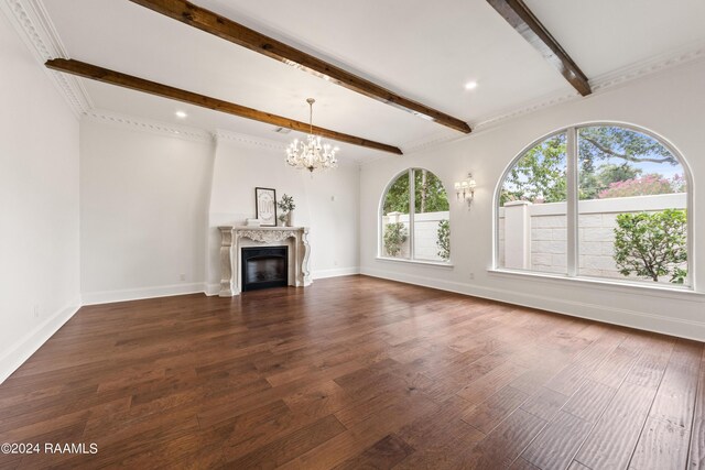 unfurnished living room with a high end fireplace, ornamental molding, an inviting chandelier, dark wood-type flooring, and beam ceiling