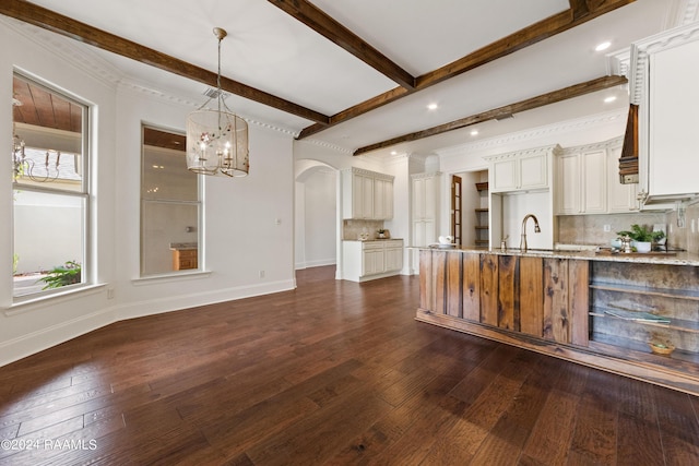 kitchen featuring beamed ceiling, baseboards, backsplash, and dark wood-style floors