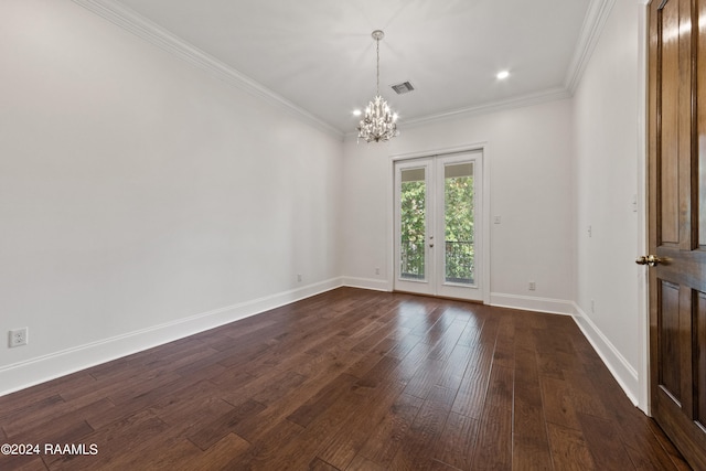 spare room with dark wood-type flooring, french doors, a notable chandelier, and ornamental molding