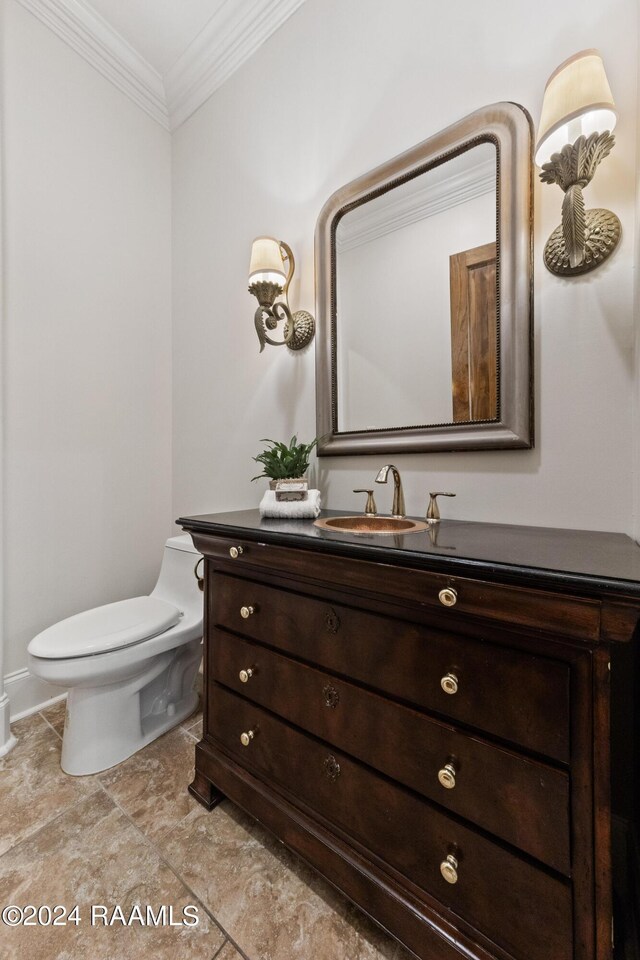 bathroom featuring vanity, toilet, and ornamental molding