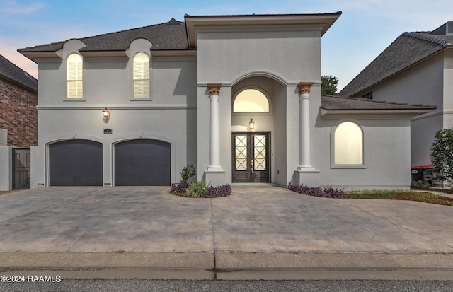 view of front of home featuring stucco siding, concrete driveway, and a garage