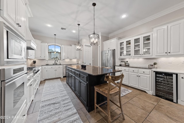 kitchen with light tile patterned floors, stainless steel appliances, beverage cooler, a kitchen breakfast bar, and a kitchen island