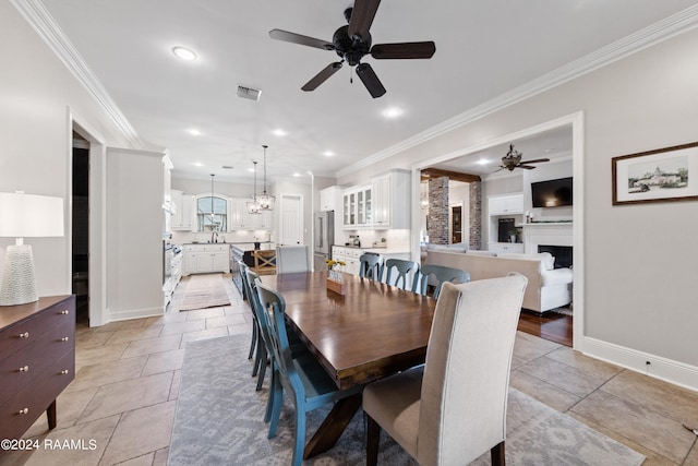 dining space with ceiling fan with notable chandelier, light tile patterned floors, and ornamental molding