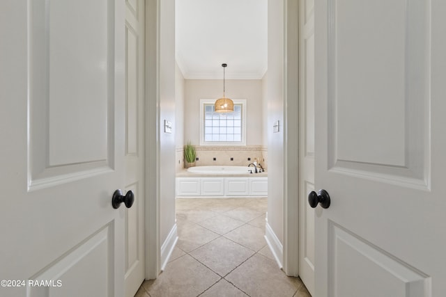 hall with crown molding and light tile patterned floors