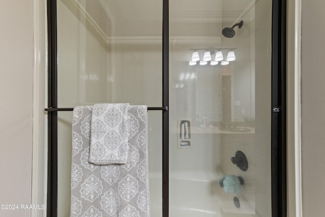 bathroom featuring crown molding and a shower with shower door