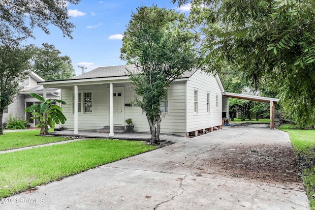 view of front of property featuring a front lawn, a carport, and a porch