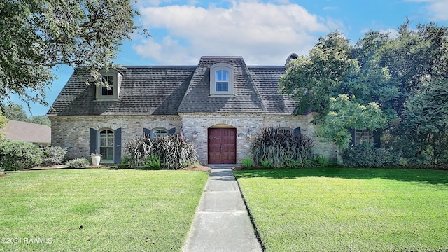 view of front of home featuring a shingled roof, mansard roof, and a front yard