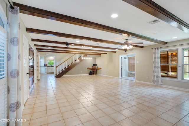 unfurnished living room featuring light tile patterned floors, beamed ceiling, baseboards, and stairs