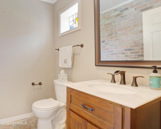 bathroom with toilet, baseboards, and vanity