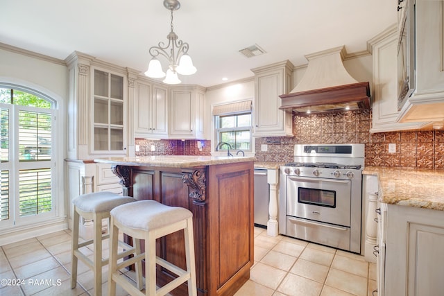 kitchen with premium range hood, visible vents, appliances with stainless steel finishes, a center island, and tasteful backsplash