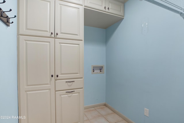 washroom featuring cabinet space, light tile patterned floors, baseboards, and hookup for a washing machine