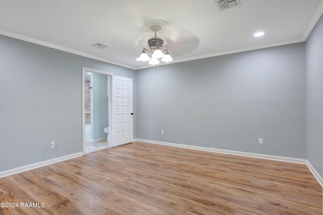 unfurnished room with crown molding, wood finished floors, visible vents, and baseboards